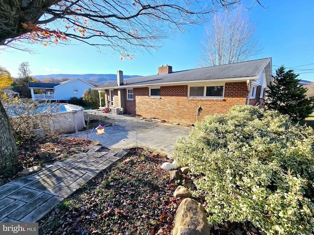 view of front of property with a mountain view and a patio area