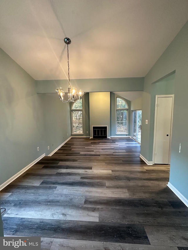 unfurnished living room with dark hardwood / wood-style flooring, lofted ceiling, and an inviting chandelier