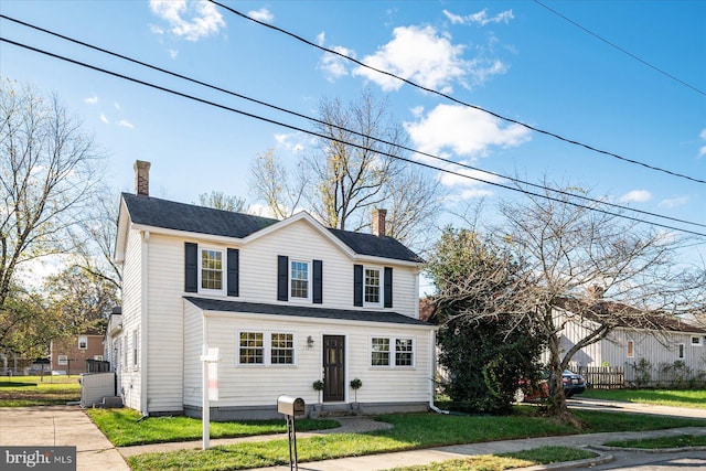 view of front facade featuring a front lawn and a chimney