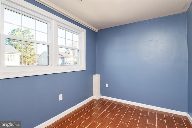 unfurnished room featuring dark wood-type flooring and ornamental molding