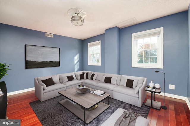 living room with healthy amount of natural light, baseboards, and wood finished floors