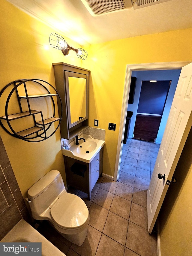 bathroom featuring tile patterned floors, toilet, vanity, and baseboards