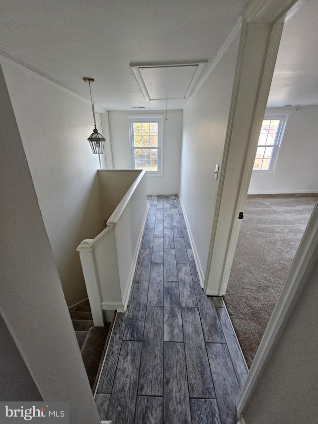 hall with attic access, an upstairs landing, dark wood-style floors, and baseboards