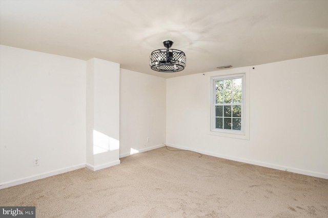 empty room with carpet floors, visible vents, and baseboards