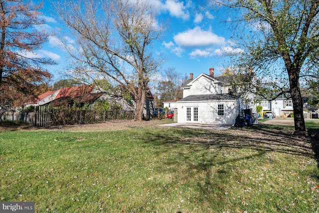 view of yard featuring french doors and fence