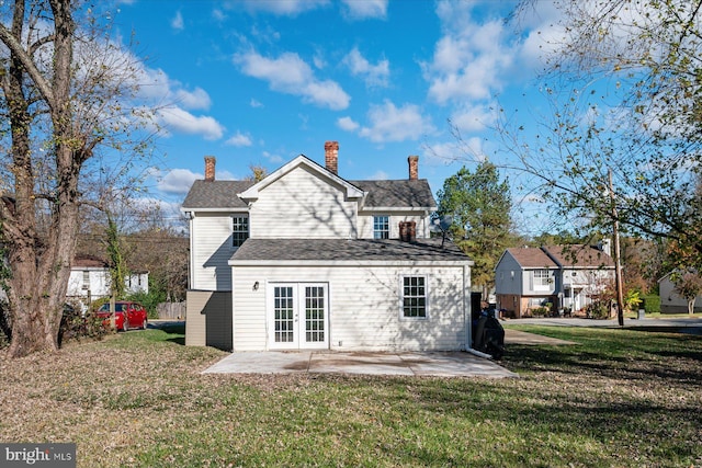 back of property with a patio area, a yard, a chimney, and french doors