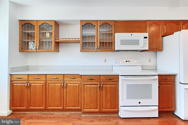 kitchen with white appliances and light hardwood / wood-style floors