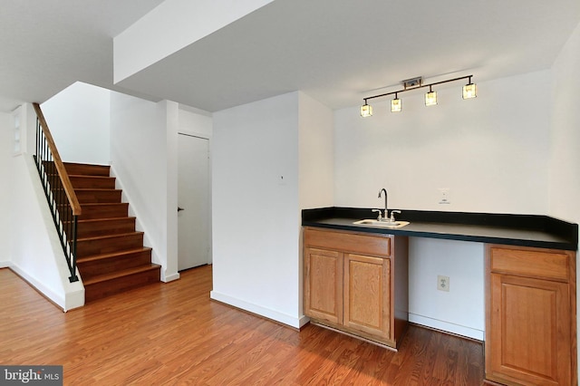 bar with hardwood / wood-style flooring and sink