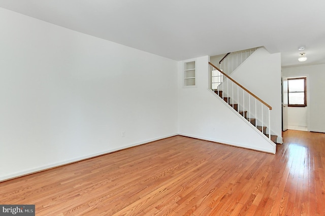 unfurnished room featuring light wood-type flooring and built in features