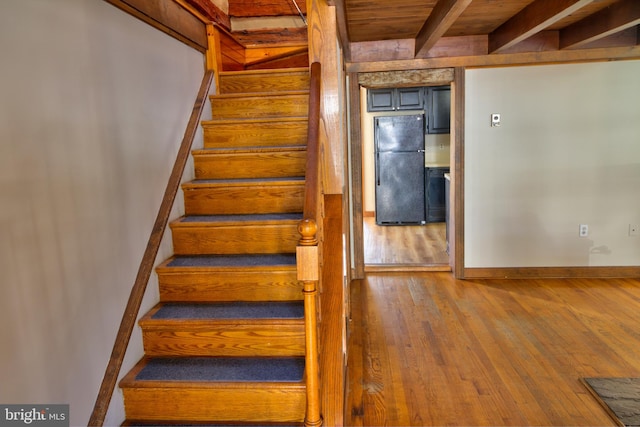 staircase featuring wood ceiling, wood-type flooring, and beam ceiling