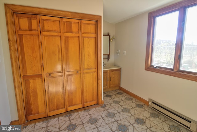 interior space featuring vanity, tile patterned floors, and a baseboard heating unit