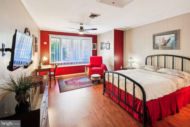 bedroom with ornamental molding, hardwood / wood-style floors, and ceiling fan