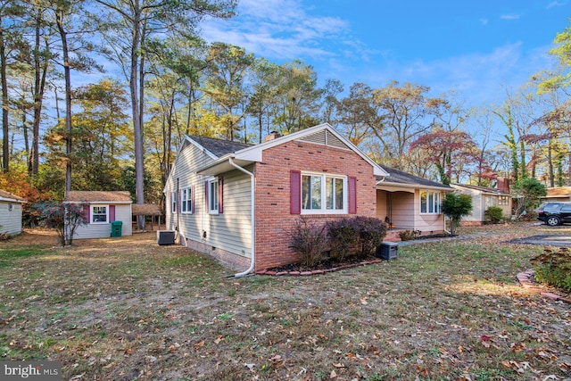 view of front of home featuring a front yard and a storage shed