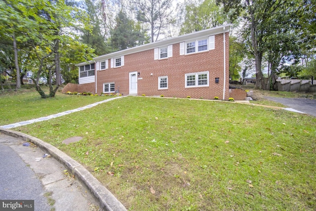 view of front of home featuring a sunroom and a front lawn