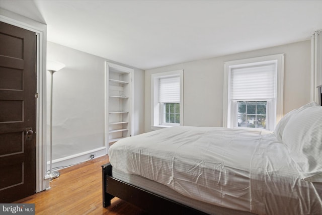 bedroom featuring wood-type flooring and multiple windows