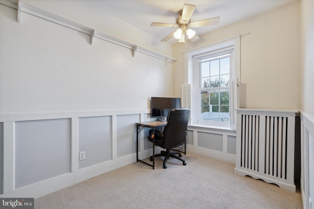 carpeted home office with beamed ceiling and ceiling fan