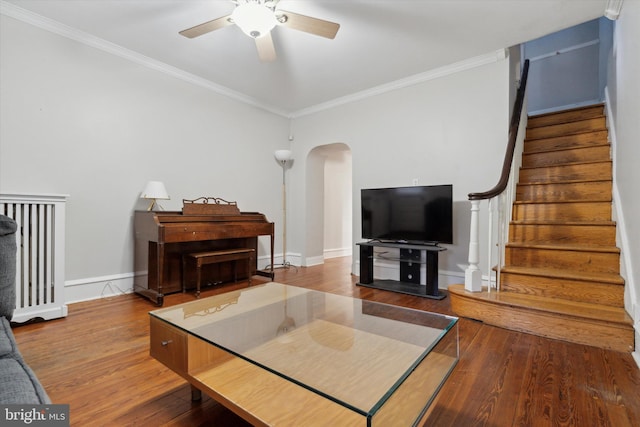 living room featuring ceiling fan, wood-type flooring, and crown molding