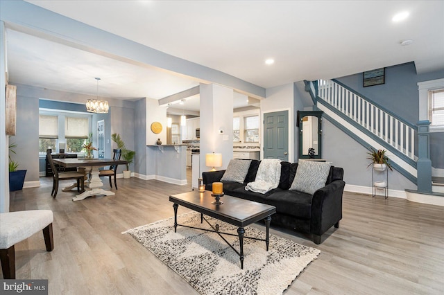 living room featuring light hardwood / wood-style floors and a notable chandelier