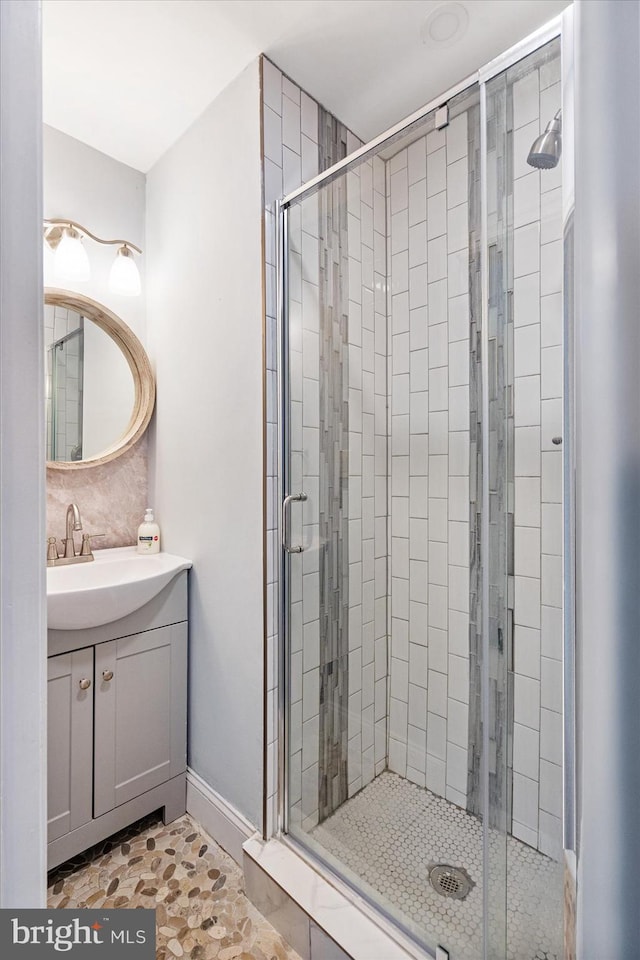 bathroom with tile patterned flooring, vanity, and walk in shower