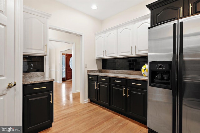 kitchen with white cabinets, stainless steel refrigerator with ice dispenser, tasteful backsplash, and light hardwood / wood-style flooring