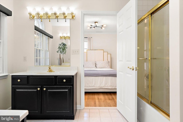 bathroom featuring tile patterned flooring, a healthy amount of sunlight, combined bath / shower with glass door, and ornamental molding