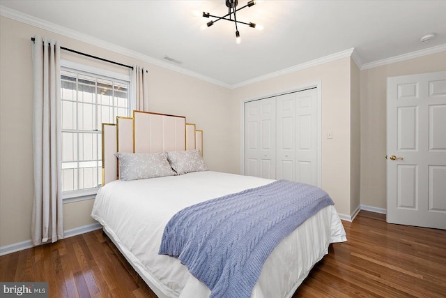 bedroom with dark hardwood / wood-style flooring, an inviting chandelier, a closet, and crown molding