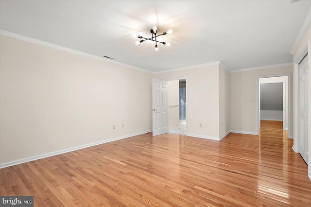 empty room featuring a chandelier, crown molding, and light hardwood / wood-style floors