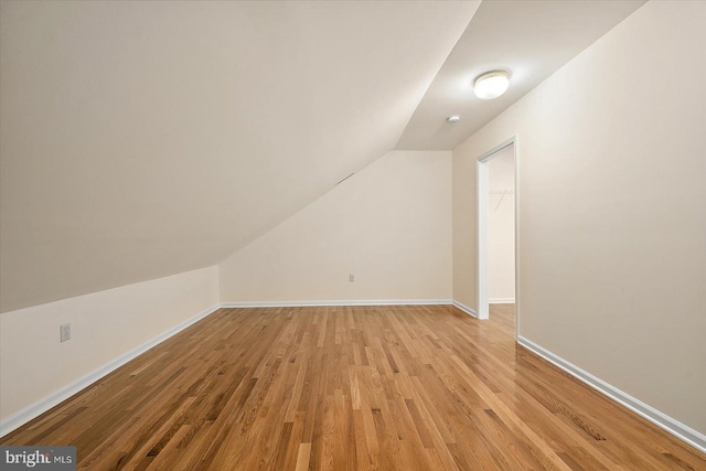 bonus room featuring light wood-type flooring and vaulted ceiling