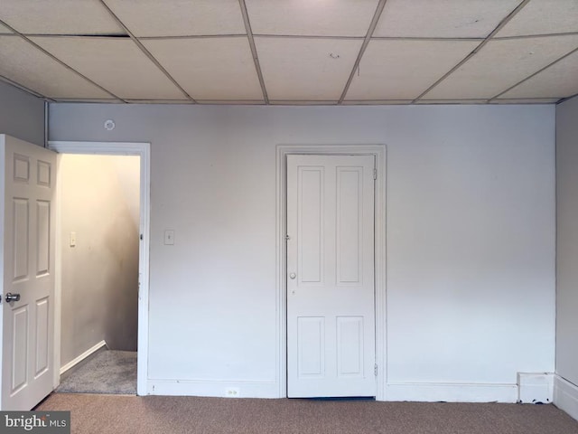 unfurnished bedroom featuring carpet and a drop ceiling