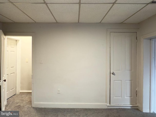 spare room featuring a paneled ceiling and carpet