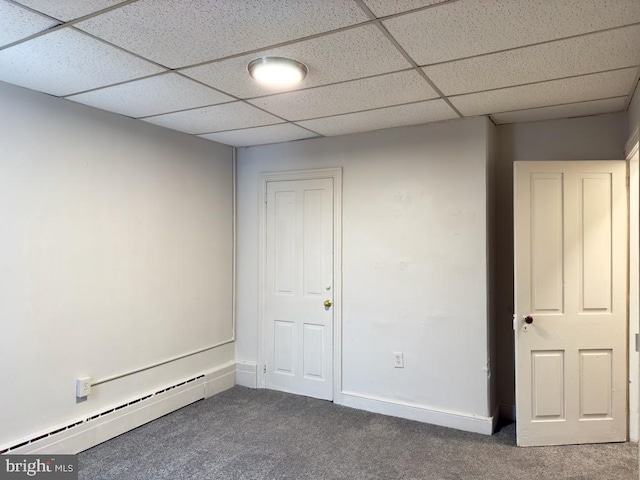 interior space with dark colored carpet, a paneled ceiling, and a baseboard radiator