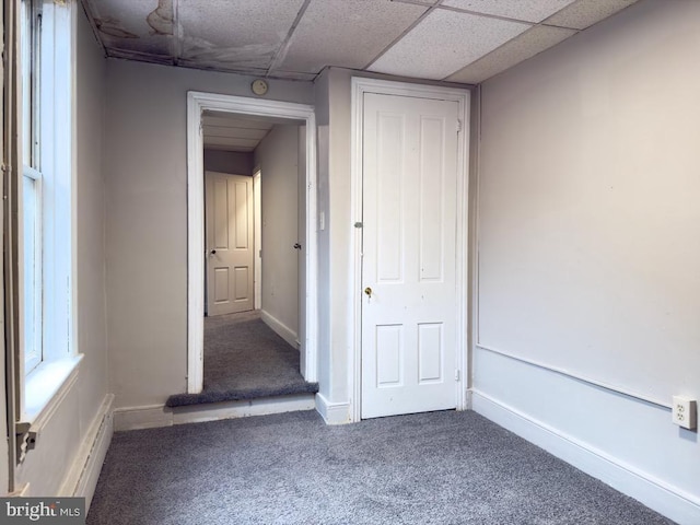 interior space with a paneled ceiling and carpet floors