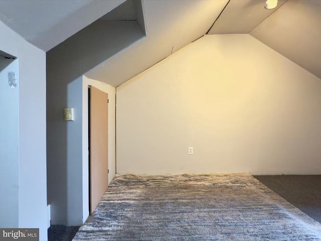 additional living space featuring carpet flooring and vaulted ceiling