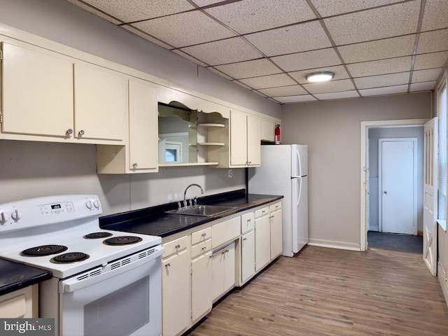 kitchen with a drop ceiling, white appliances, sink, white cabinets, and light hardwood / wood-style floors