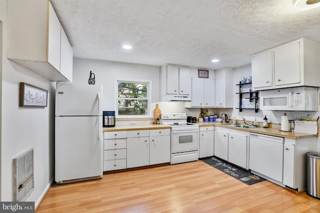 kitchen featuring sink, white cabinets, light hardwood / wood-style floors, and white appliances