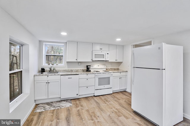 kitchen with light stone countertops, sink, light hardwood / wood-style flooring, white appliances, and white cabinets