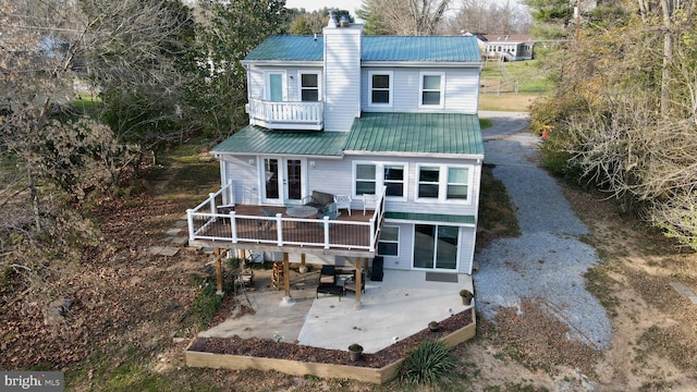 back of house with a balcony, a deck, and french doors