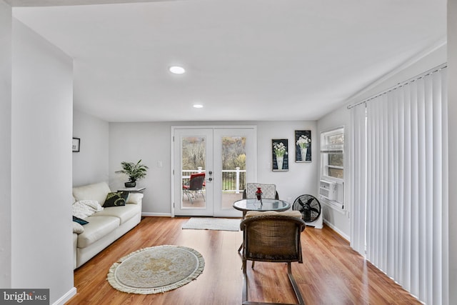 living room featuring french doors, light hardwood / wood-style flooring, and cooling unit