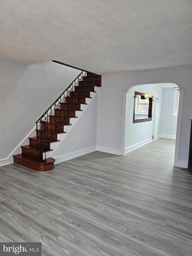 unfurnished living room with light hardwood / wood-style floors and a textured ceiling