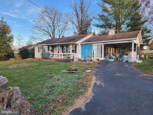 ranch-style house with a front yard, a carport, and a porch