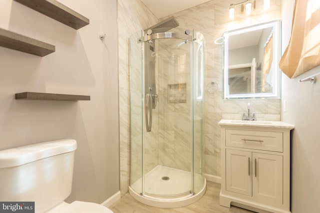 bathroom with a shower with shower door, vanity, toilet, and wood-type flooring