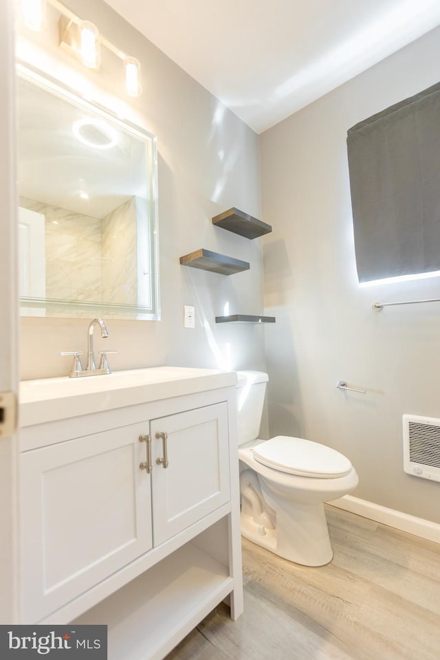 bathroom featuring hardwood / wood-style floors, vanity, toilet, and heating unit