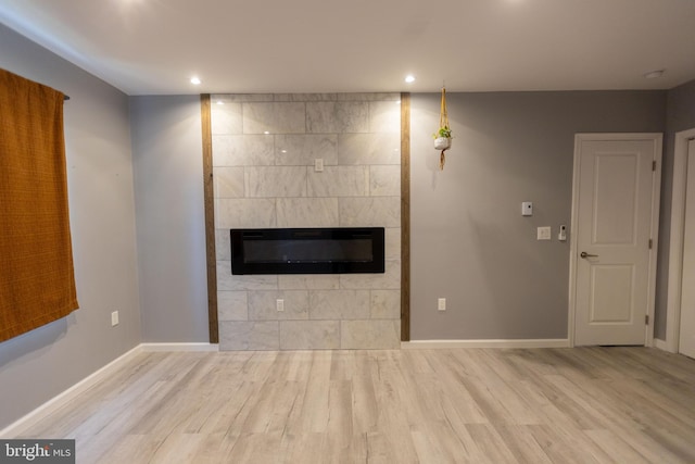 unfurnished living room featuring a fireplace and light hardwood / wood-style floors