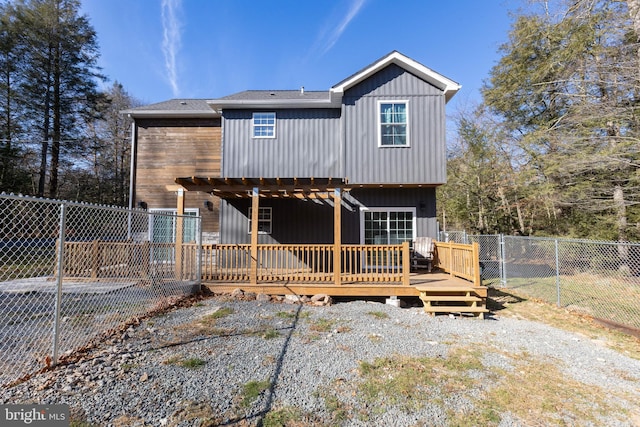 rear view of property featuring a wooden deck and a pergola