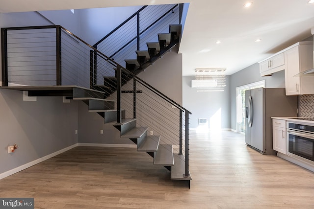 stairs featuring hardwood / wood-style floors