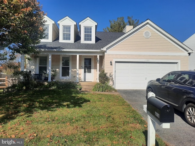 new england style home featuring a front lawn, a garage, and covered porch