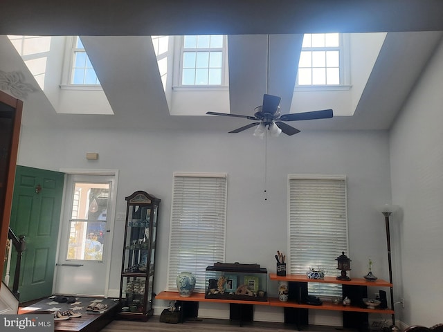 office area with hardwood / wood-style floors, a towering ceiling, and ceiling fan