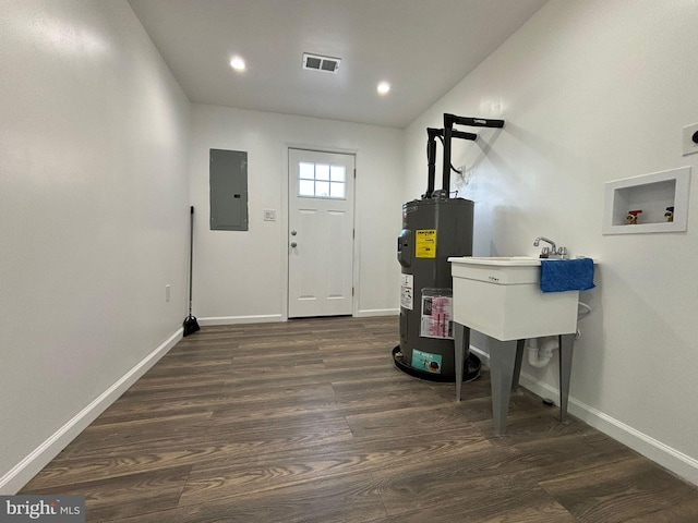 interior space with water heater, electric panel, washer hookup, and dark hardwood / wood-style floors