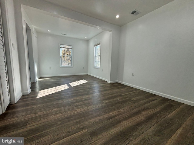 unfurnished room featuring dark wood-type flooring, baseboards, and recessed lighting