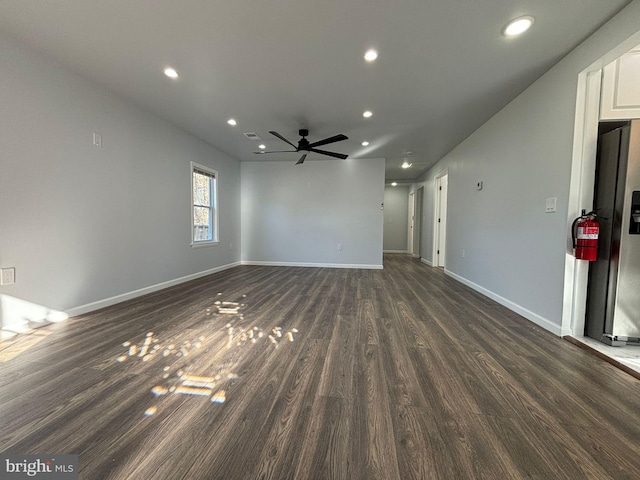 unfurnished living room featuring ceiling fan and dark hardwood / wood-style floors